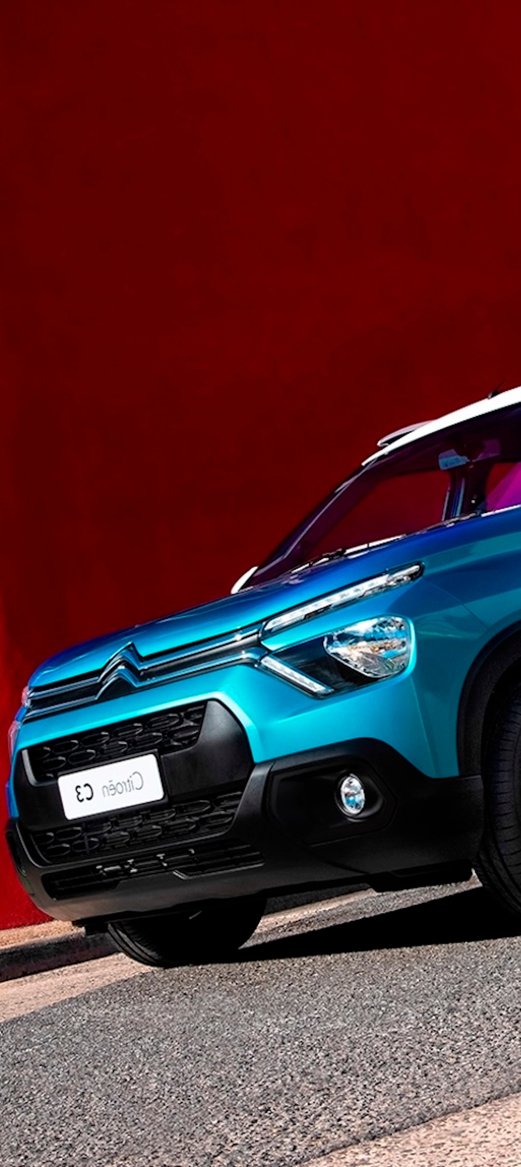 Citroën C3 Rouge con puesta de sol y ciudad de fondo